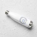Stainless steel water bottle from SCD One laying on a flat surface with a left tilt